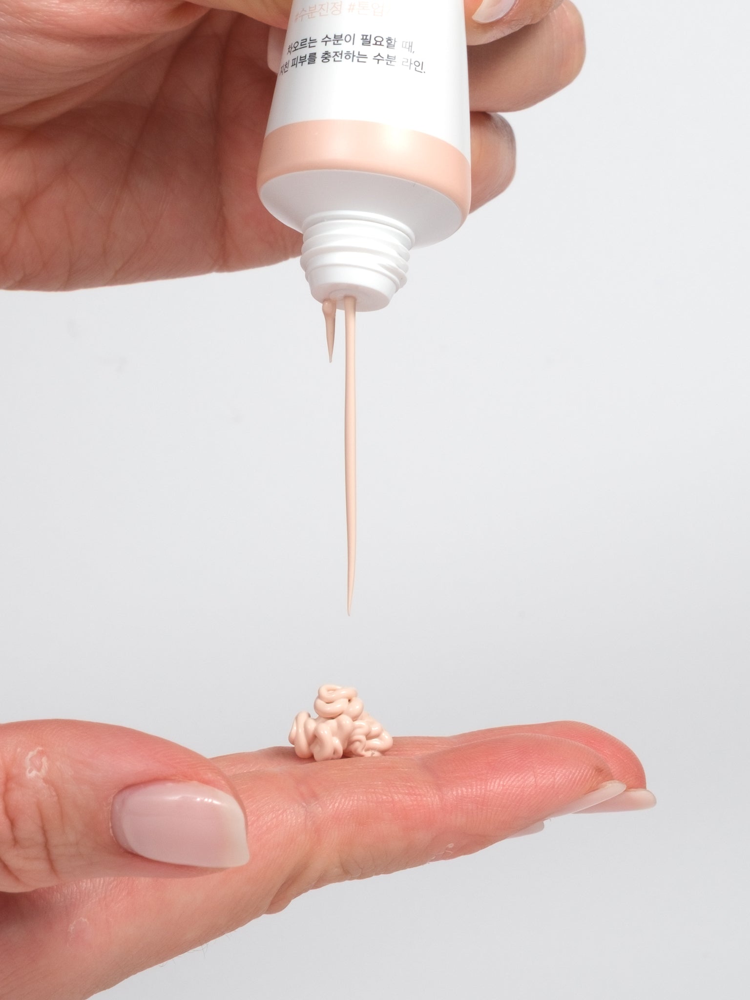 Close-up of Round Lab Birch Juice Tone Up Sunscreen showing its soft peach-apricot tinted texture