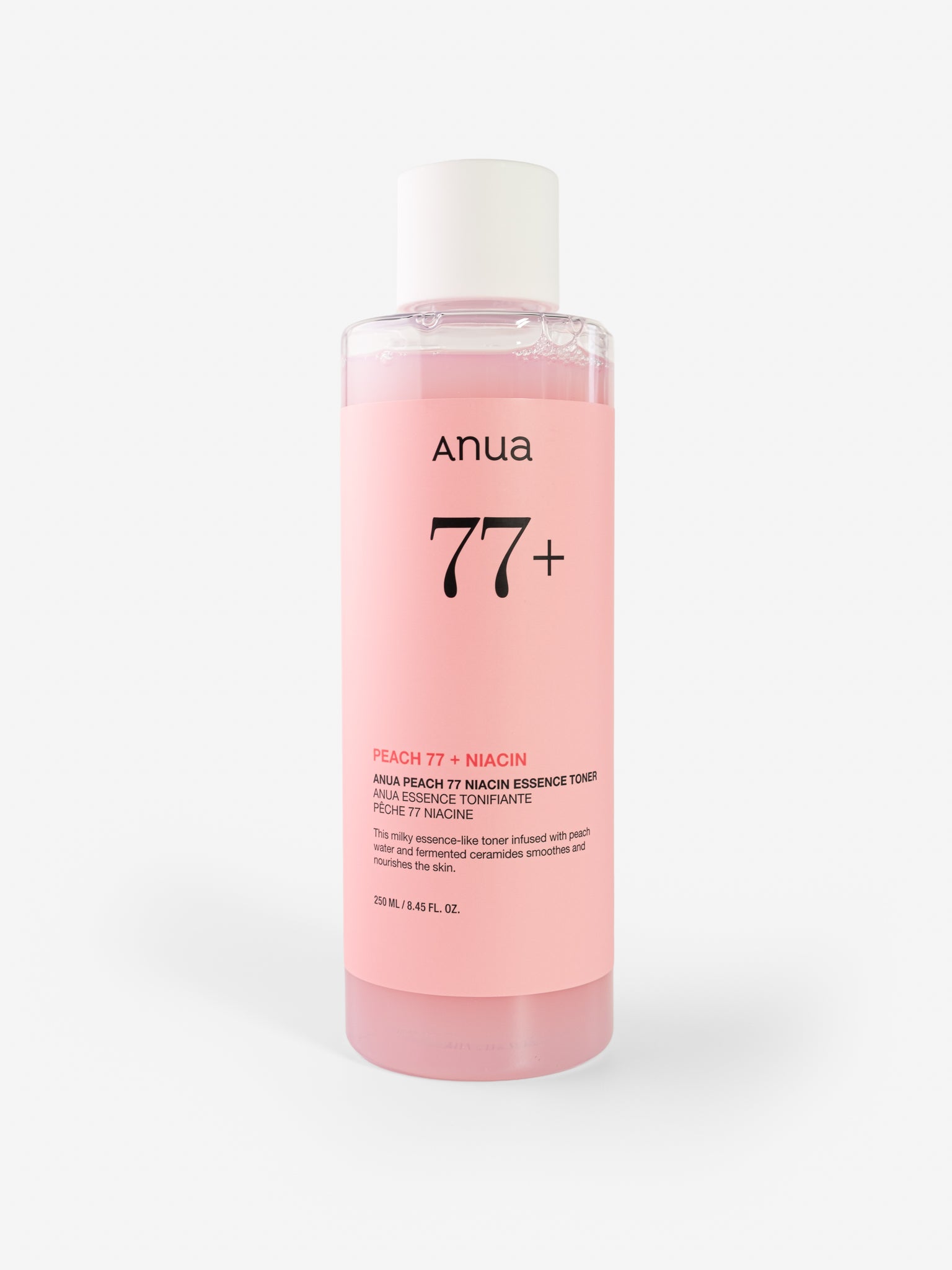 Pink bottle of anua 77+ essence toner on a white background
