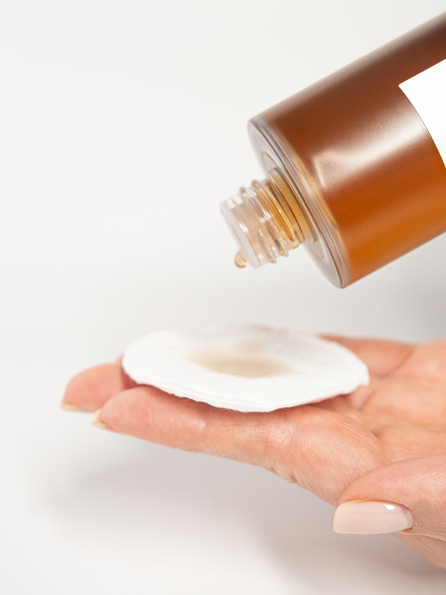 Beauty of Joseon Ginseng Essence poured on to a cotton pad on white background