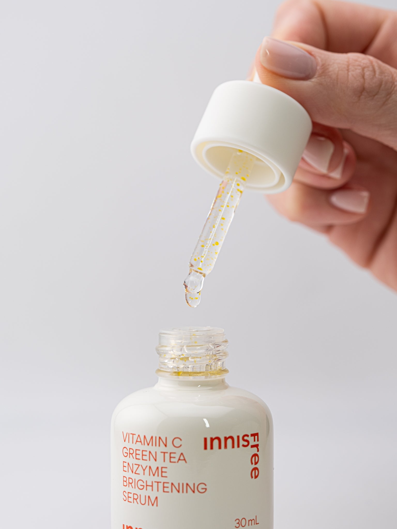 Innisfree Vitamin C Green Tea Enzyme Brightening Serum with dropper on a white background