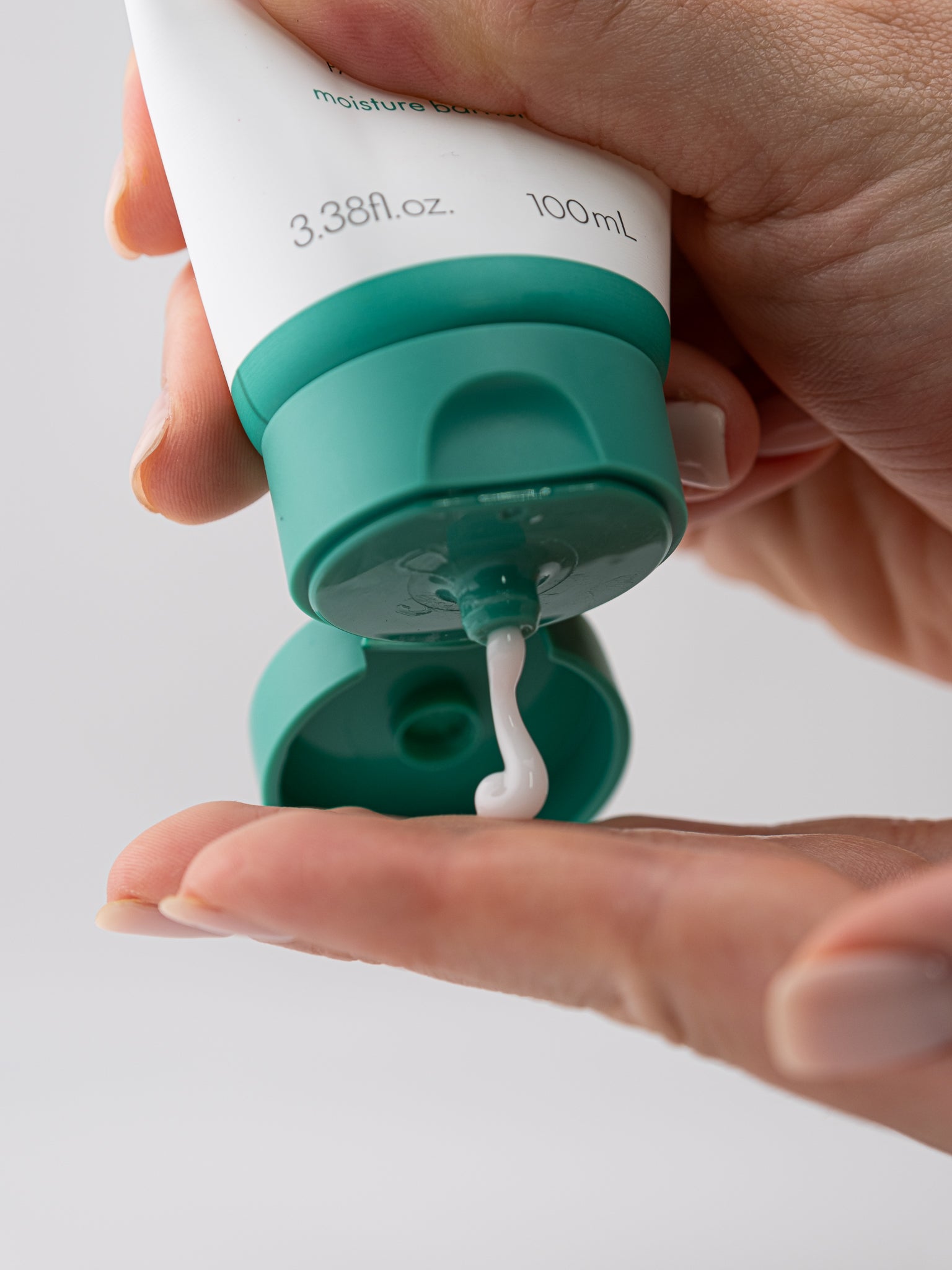 Hand holding mighty bamboo panthenol bottle with a small amount on a finger.