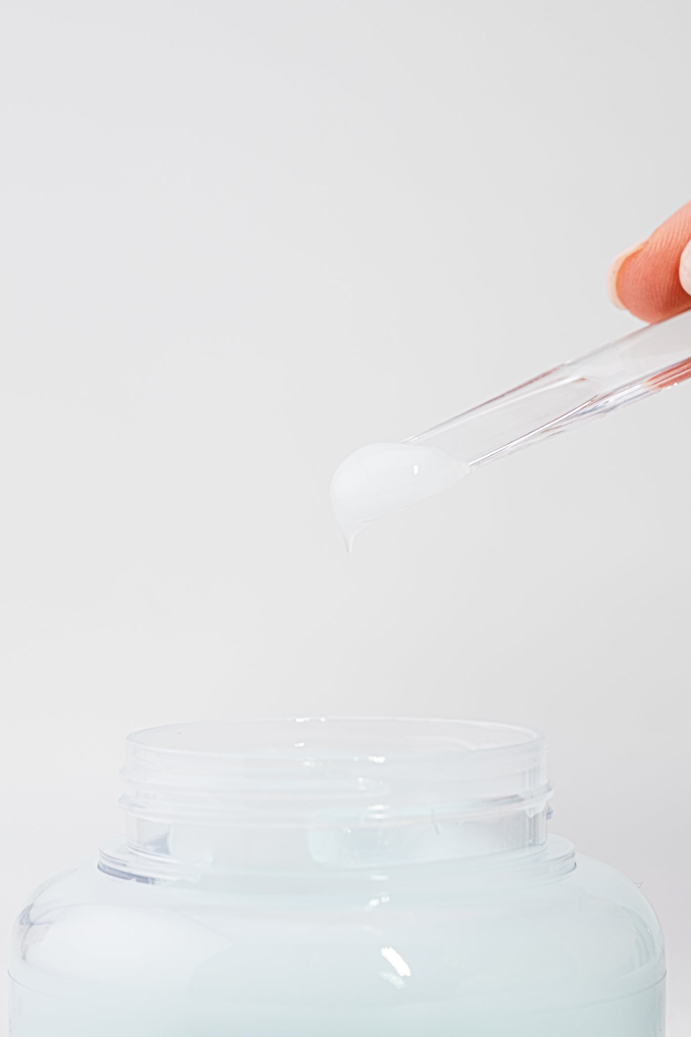 Texture of dive-in low soothing cream held by a hand against a light gray background