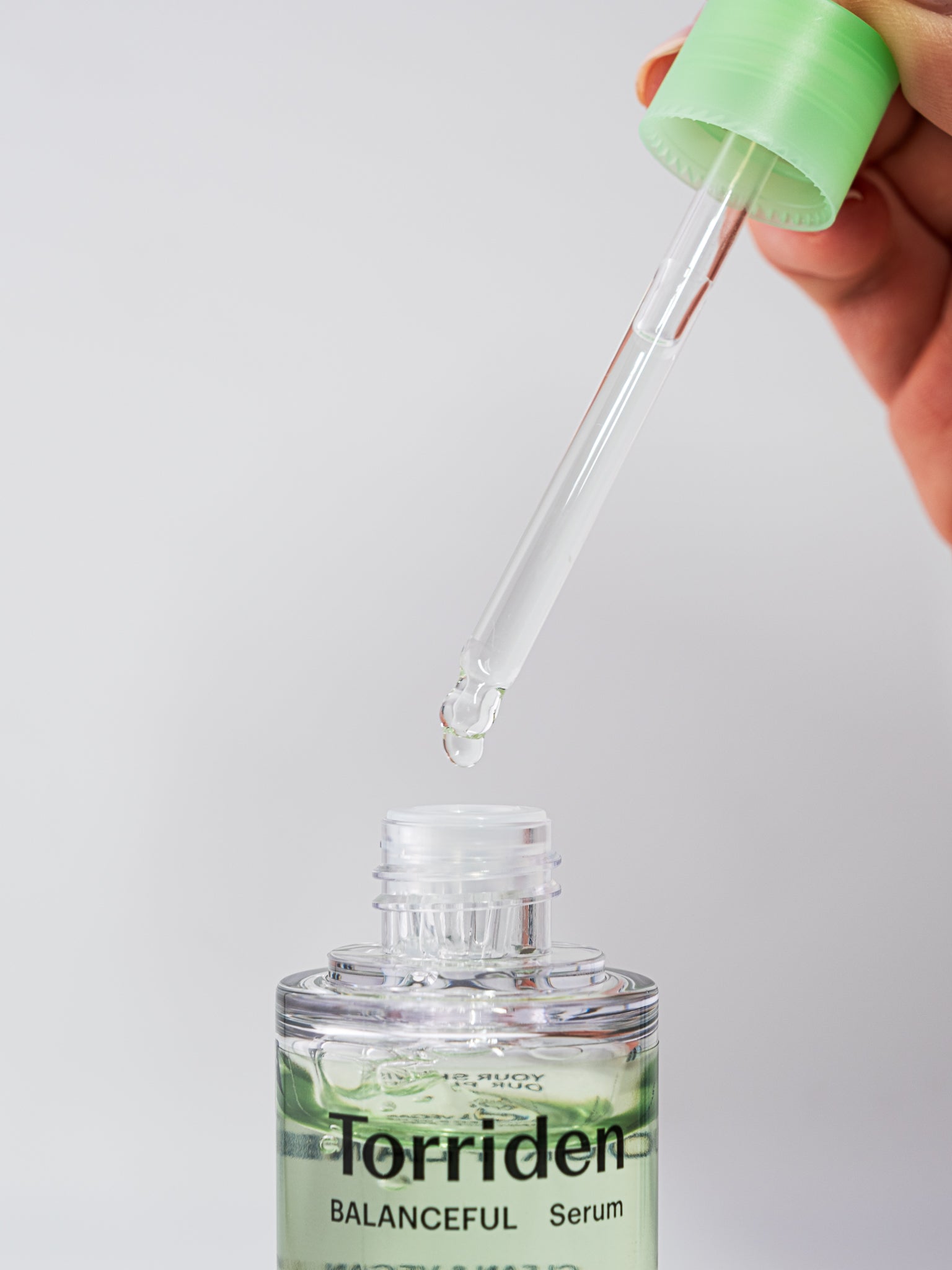 Torriden Balanceful Serum with dropper on a light gray background
