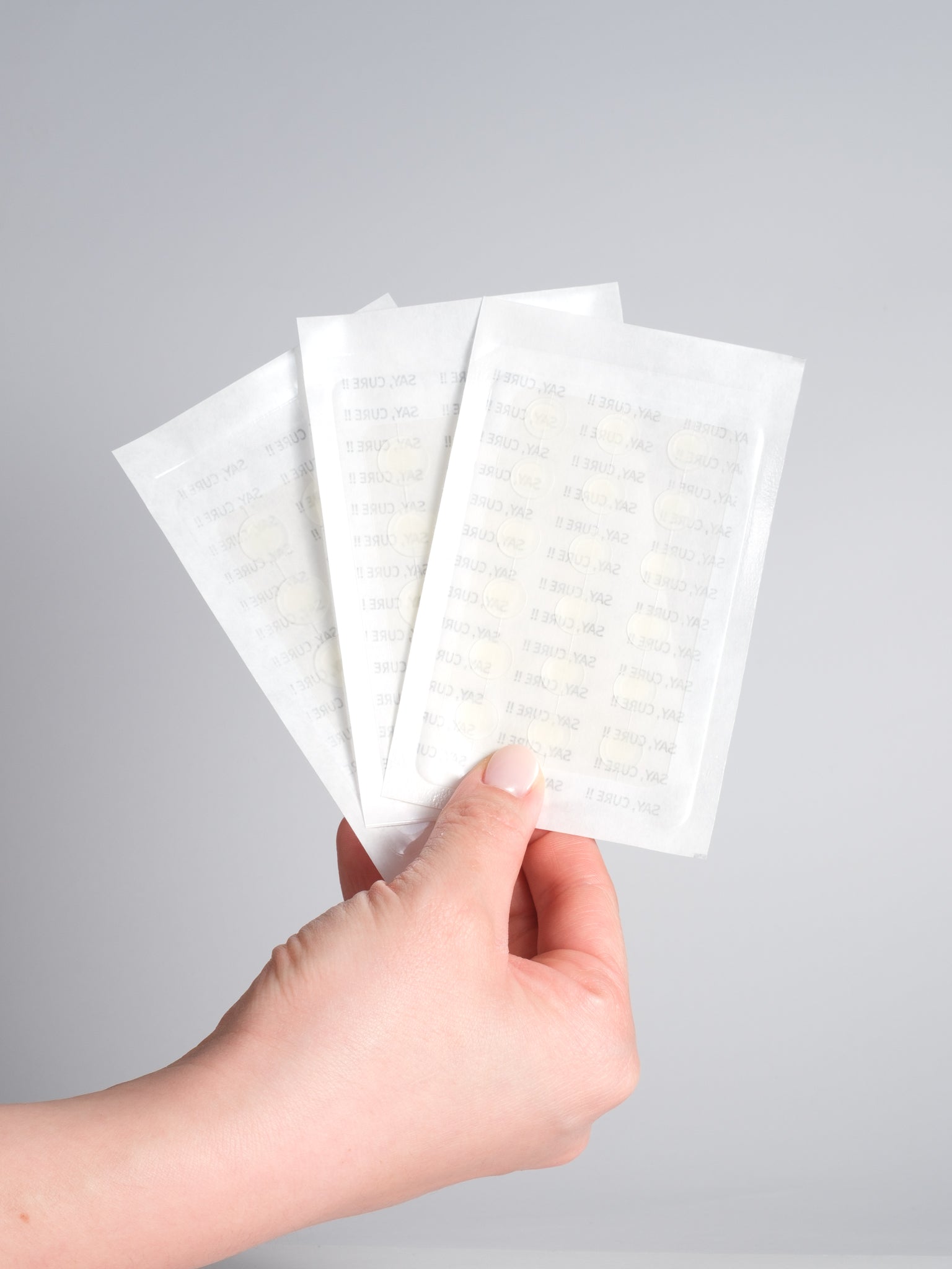 Three sheets of VT PRO Cica Tiger Clear Spot Patch fanned out in hand